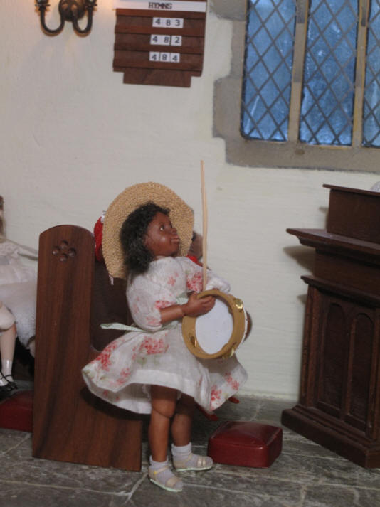 Grace has walked over to the church in order to practice processing with both a palm leaf AND whilst playing her tambourine and singing....